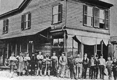 The employees of the Harris Automatic Press Co. around the turn of the previous century. Charles and Alfred Harris are the fourth and fifth gentlemen from the right. The house in the picture was the boyhood home of William McKinley; later it served as the Harris Company's first plant. The house stood on the site of the proposed reconstruction of McKinley's home, and the Old Main Ale & Chowder House.