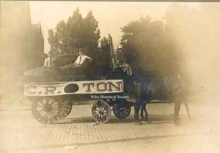 Horse drawn wagon moving furniture with C.R. Holeton atop the wagon in front of Methodist Church at corner of West Park Avenue and Arlington.