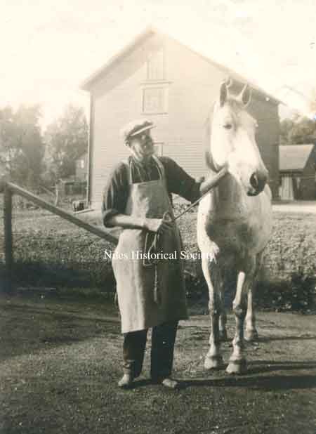 Henry behind the store with one of the horses that pulled the H.F. Rider Store wagon to deliver groceries and dry goods.