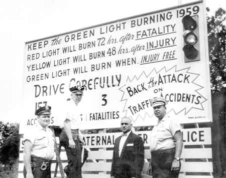 Injury Light located at the side of Robbins and Vienna Avenues. Pictured are John 'Burgaundy' Marsico, Glen Smith, Police Chief Ross and John Scott. Photo 1959