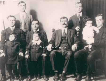 Isaac Shaker's brother Joseph holding toddler Mitchell Shaker, Isaac Shaker's father Shaker Aoud, Isaac Shaker with young son Simon Shaker in front, Isaac Shaker's brother Samuel with unknown toddler in front. Back row left Fred Joseph and Isaac's brother and partner in the store Akel Shaker.