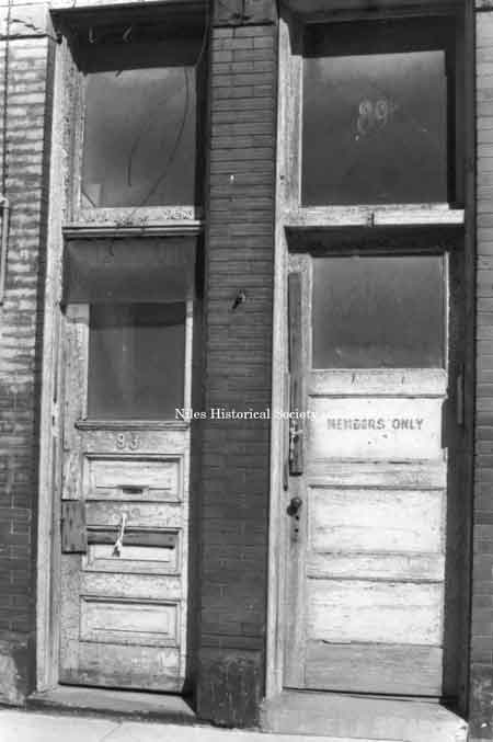 Photo taken showing marked deterioration on doors and other details on unidentified building in downtown Niles.
