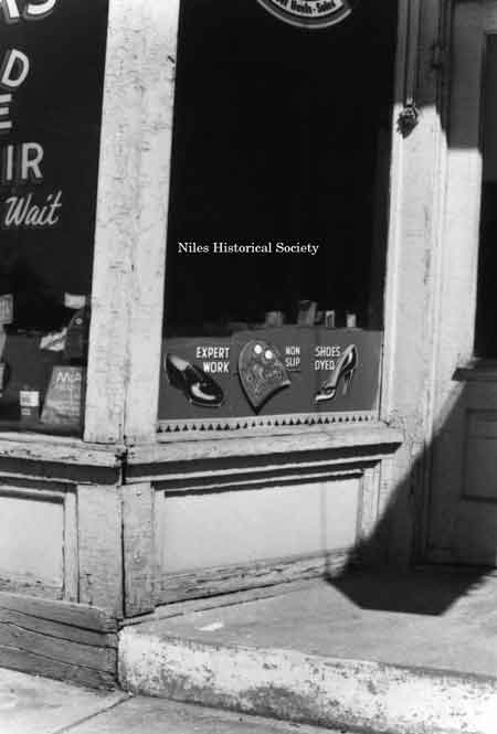 Photo taken of detail storefront of Cooks Rapid Shoe Repair, located on East State Street.