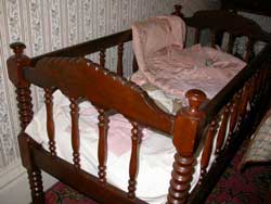 Carved spindle bed in upstairs room of Ward-Thomas Museum