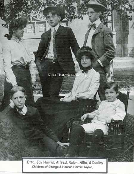 Photograph of the Taylor children taken on the front lawn of their home on Arlington Street with the First Christian Church in the background.