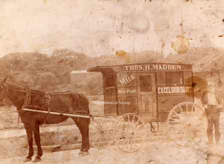 A badly damaged photo of a horse and wagon run by Thomas Madden at some time before the turn of the century as Excelsior Dairy.