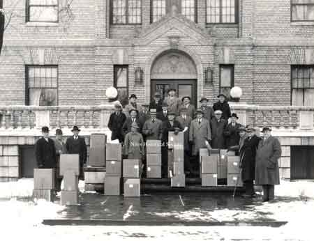 A group of men in front of the Niles Masonic Lodge with large boxes. It is safe to assume that these men are Masons and the boxes may have something to do with food relief, indicating the depression era.